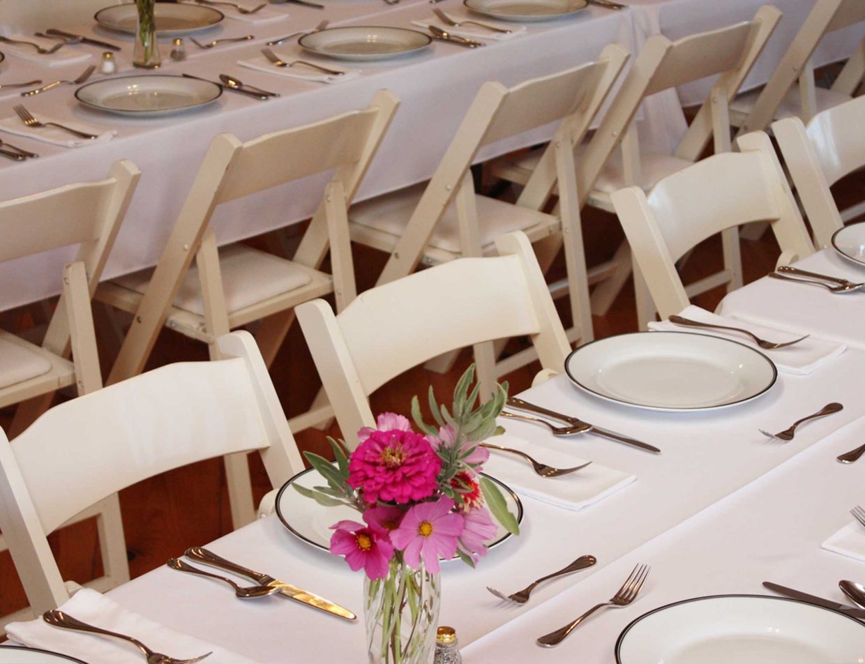 Wedding reception table place settings with pink flowers