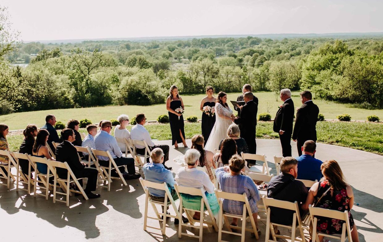 guests are gathered on the patio at cedar crest lodge for a wedding as the bride and groom are married