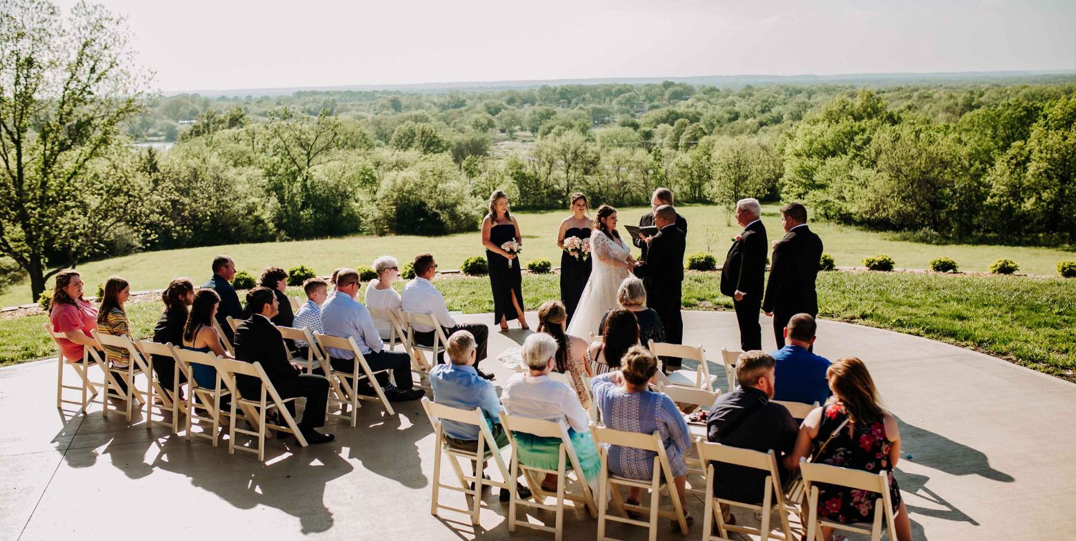 guests are gathered on the patio at cedar crest lodge for a wedding as the bride and groom are married